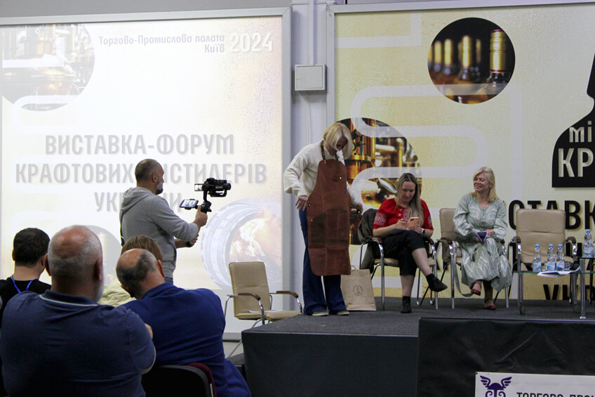 Голова АКДУ Катерина Камишева демонструє головний приз дегустаційного сету на звання PROFI CHOICE – шкіряний фартух Майстра дистилера.